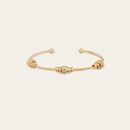 Gold bracelet with small turquoise beads on a white background