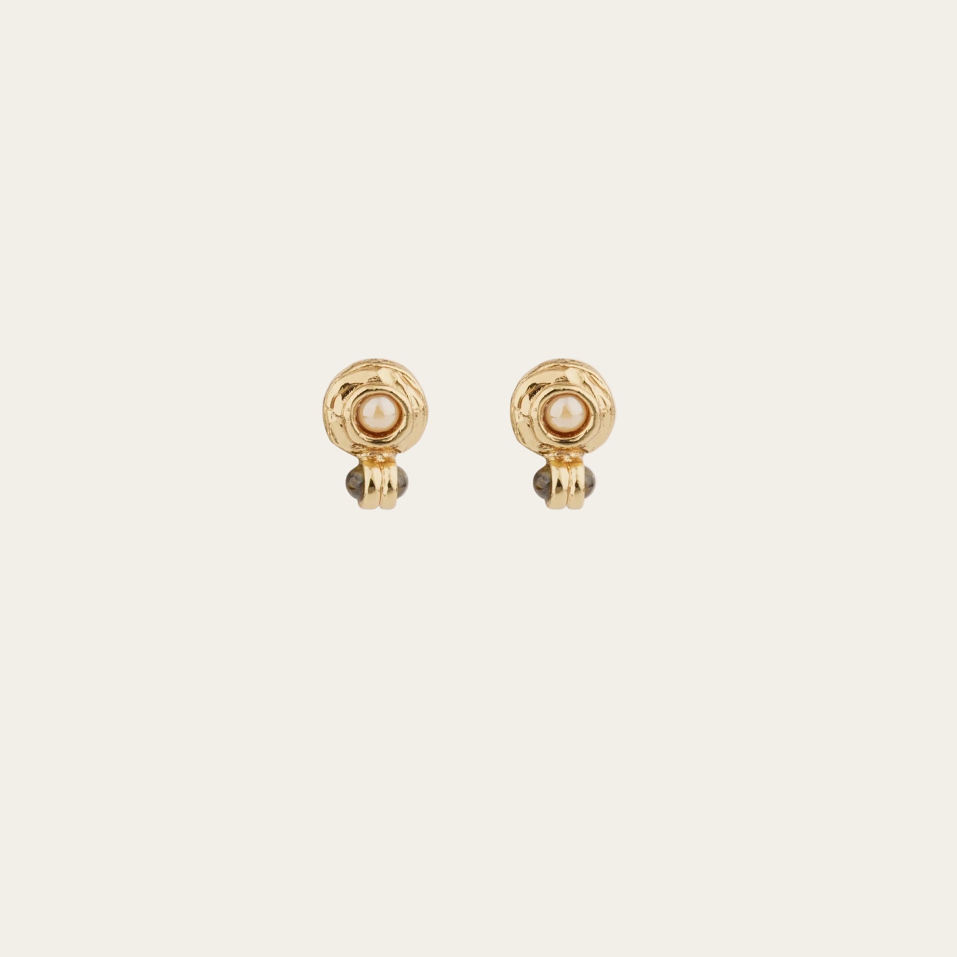 Two gold earrings with pearl on a white background