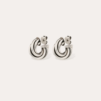 Pair of silver hoop earrings on a light beige background