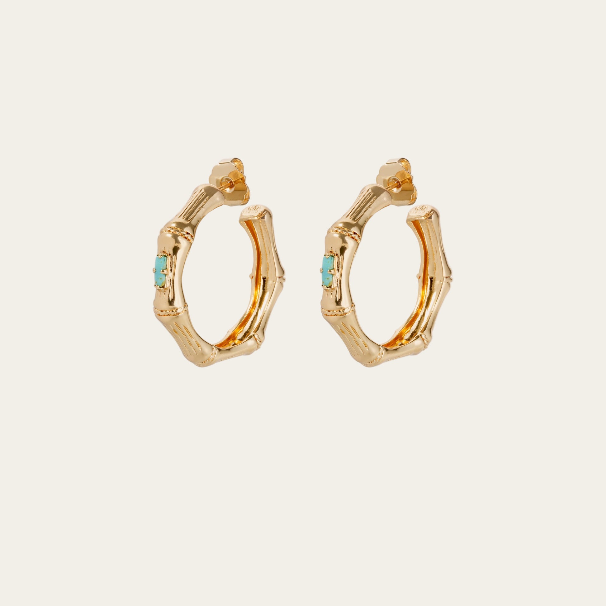 Gold hoop earrings with turquoise stones on a white background
