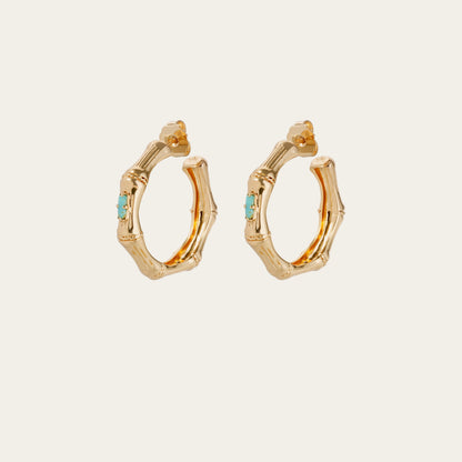 Gold hoop earrings with turquoise stones on a white background