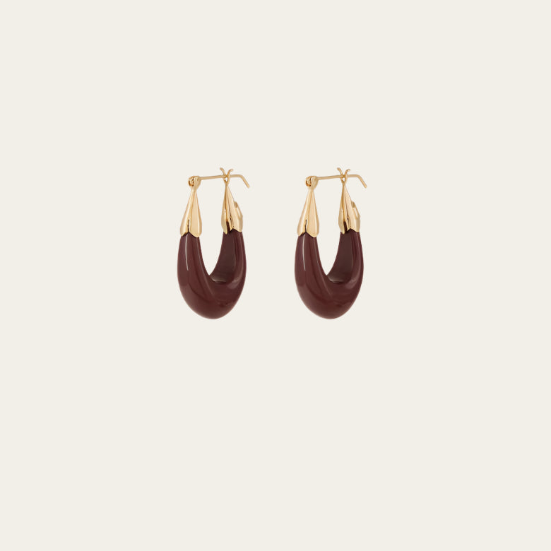 A pair of gold-tone drop earrings with a smooth finish and dark maple resin accents.