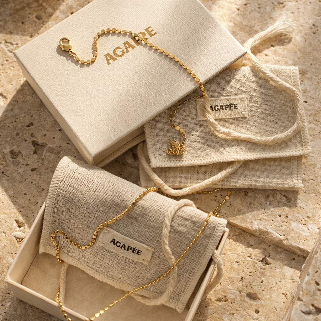 Gold jewelry with 'ACAPEE' branding on textured stone surface