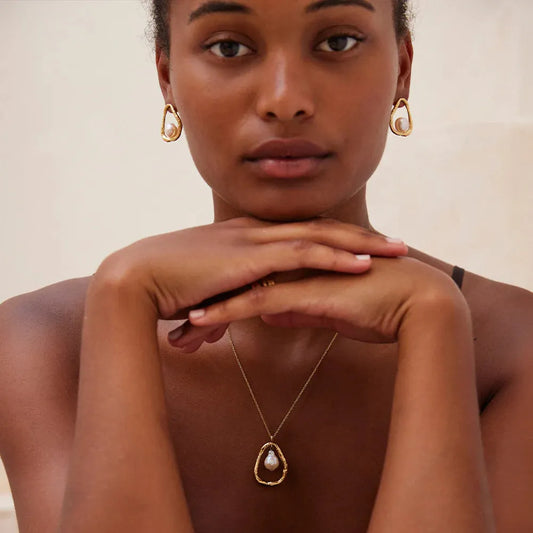 Model wearing Agapée Ostuni pearl earrings with a matching pearl pendant necklace