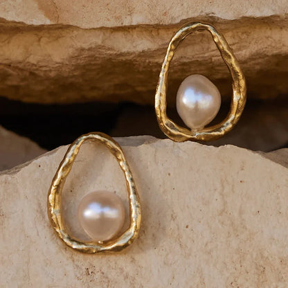 AGAPEE OSTUNI GOLD PEARL EARRINGS SCENE SHOT ON ROCKS