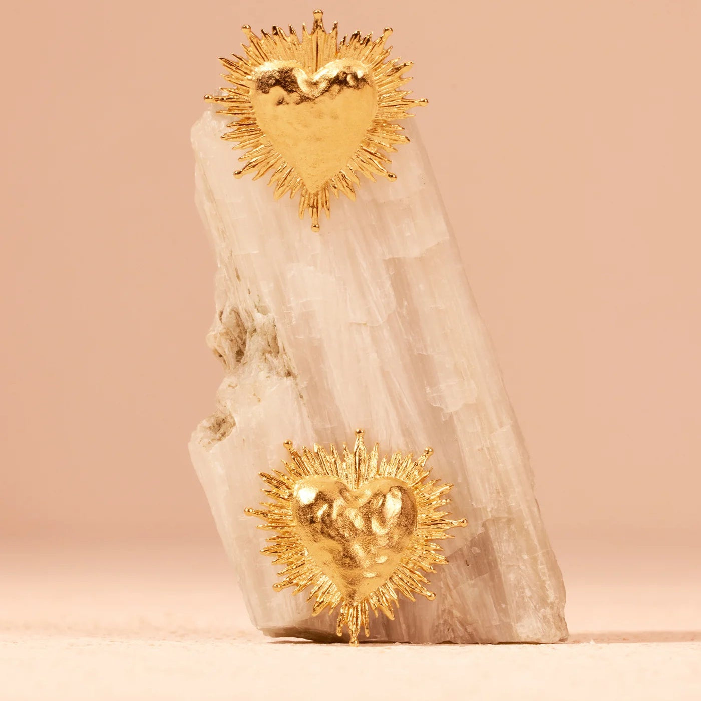 Decorative item with gold heart-shaped sun designs on a beige background