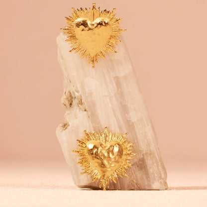 Decorative item with gold heart-shaped sun designs on a beige background