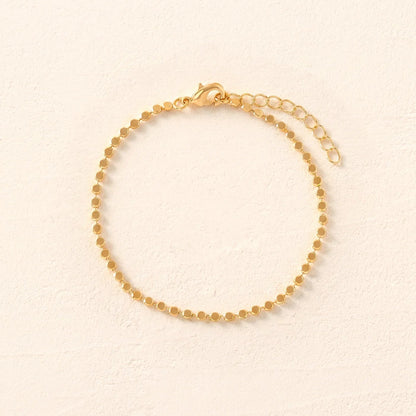 Gold bracelet on a beige background