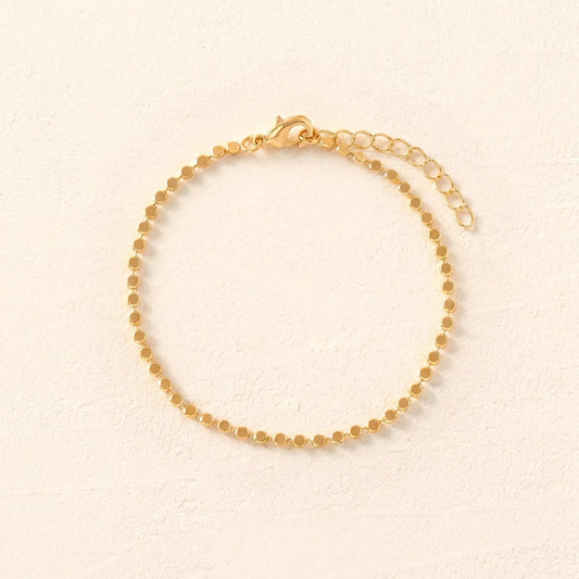 Gold bracelet on a beige background