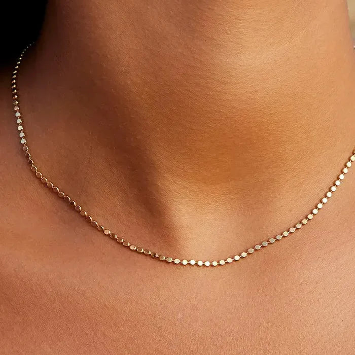 Gold necklace on a person's neck