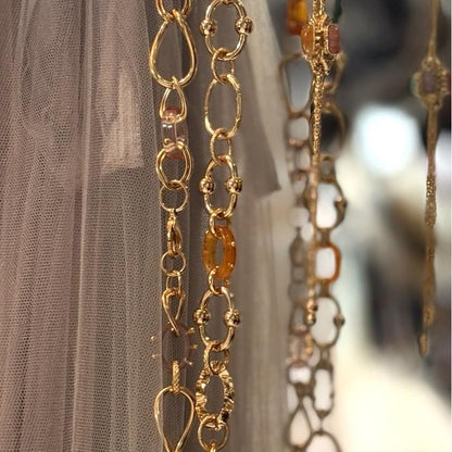 Close-up of gold necklaces with gemstones against a blurred background
