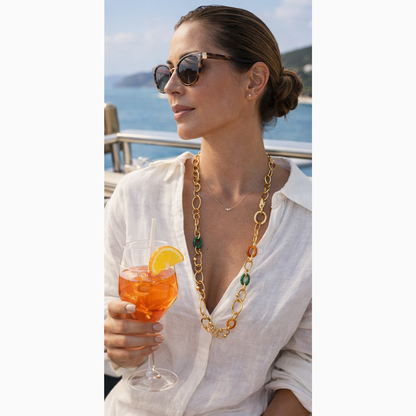Woman holding a cocktail with sunglasses and a scenic background