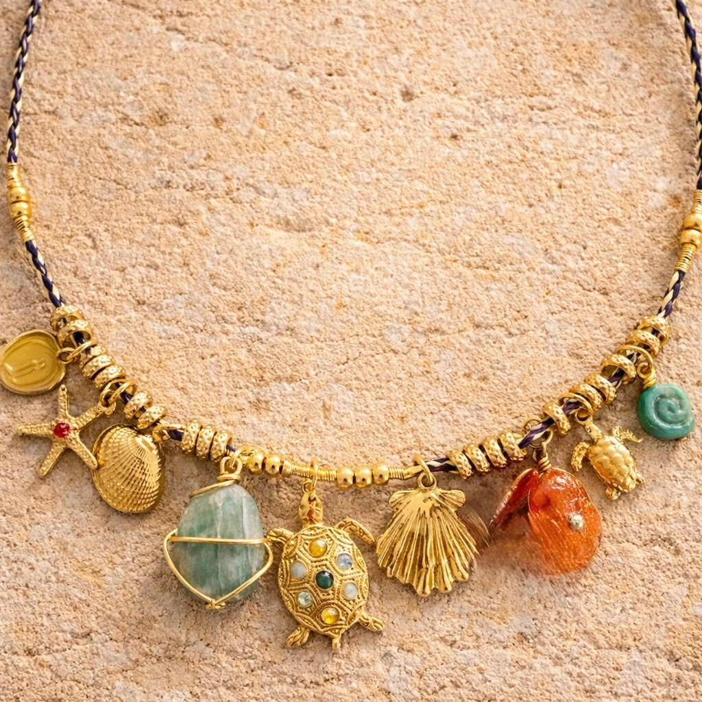 Necklace with various charms on a beige textured background