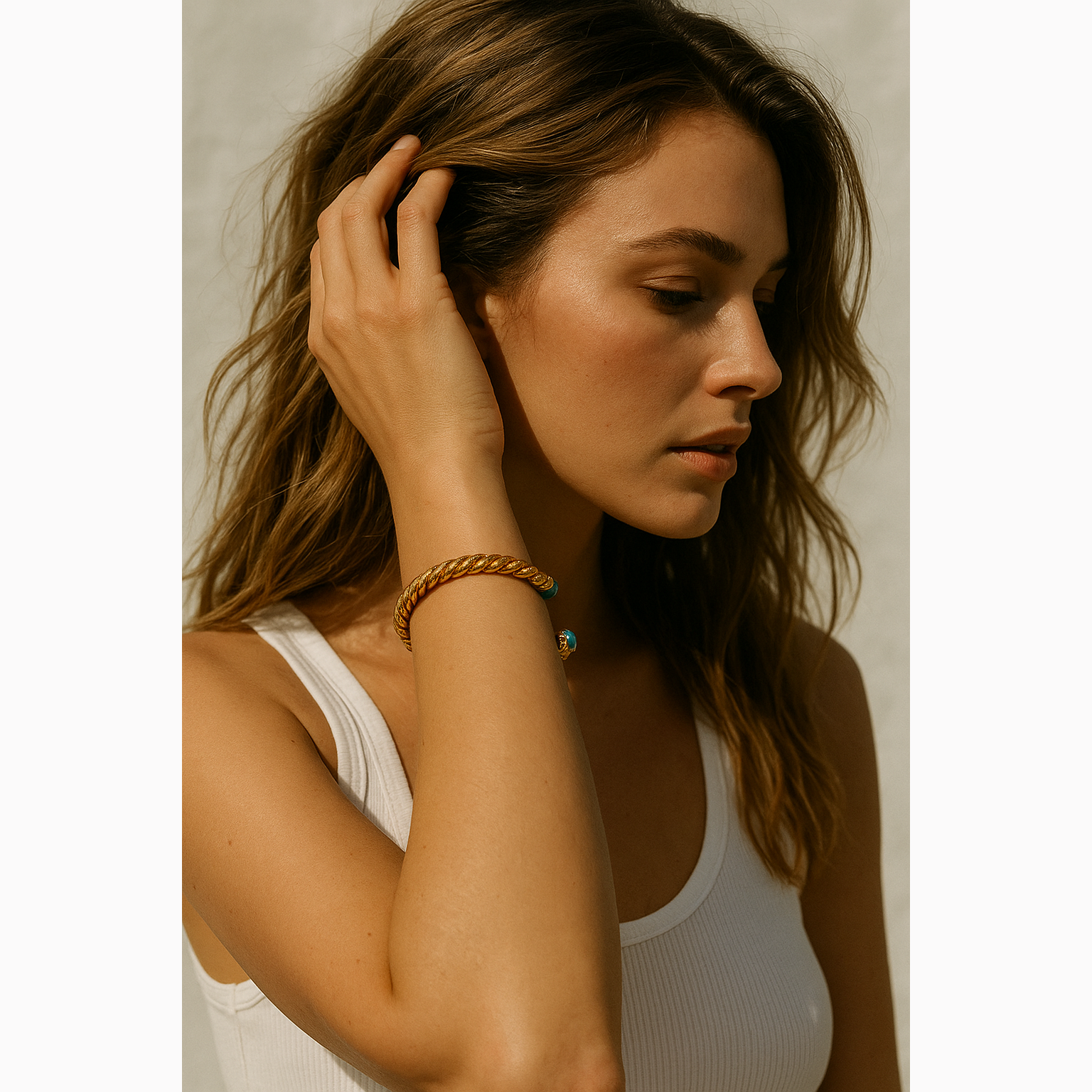 woman wearing gold bracelet with neutral background