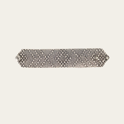 Silver bracelet with a textured pattern on a light gray background