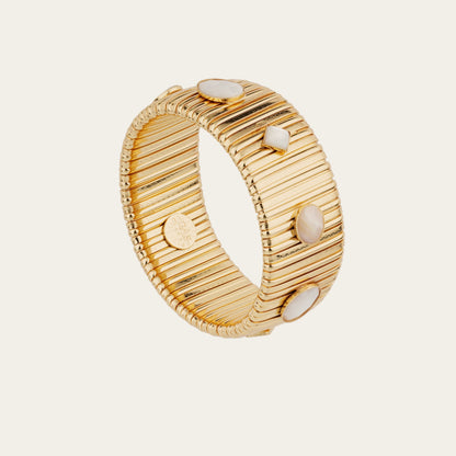 Gold bracelet with textured design and embedded mother of pearl stones on a light gray background