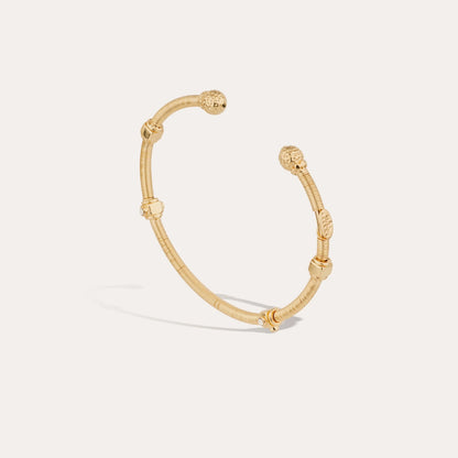 Gold bracelet on a light gray background