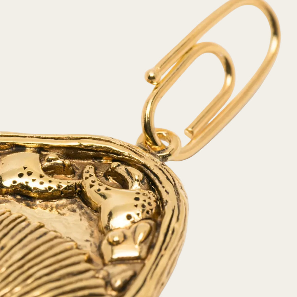Gold pendant with bull design on a white background