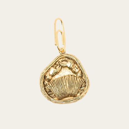 Gold pendant with a detailed design on a white background