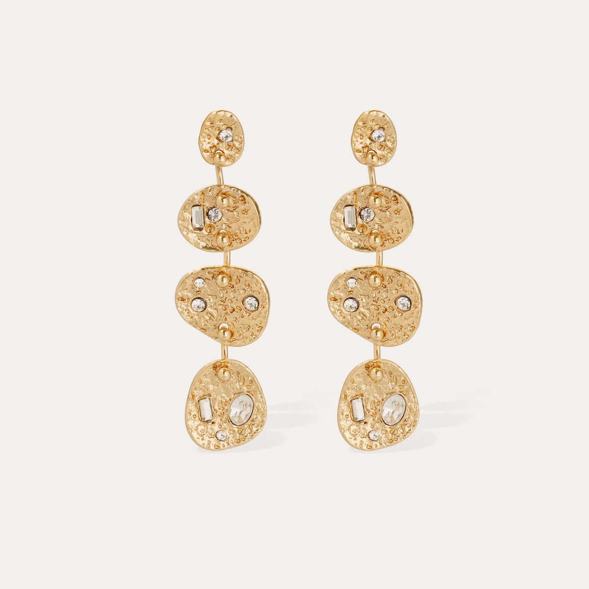 Model wearing Gas Bijoux Éclipse Strass gold-plated drop earrings with hammered linked discs and clear strass detailing, with hair swept back.