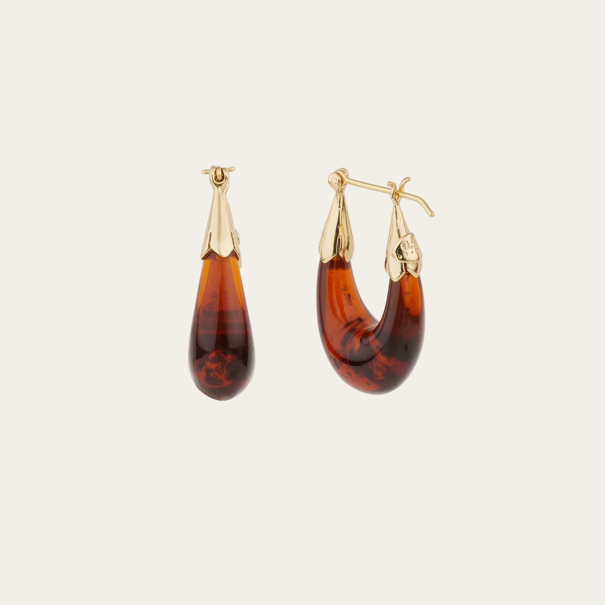 Pair of tortoiseshell hoop earrings with gold accents on a white background