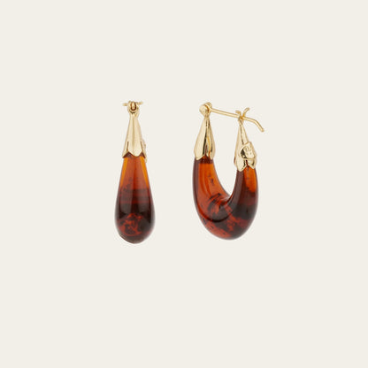 Pair of tortoiseshell hoop earrings with gold accents on a white background