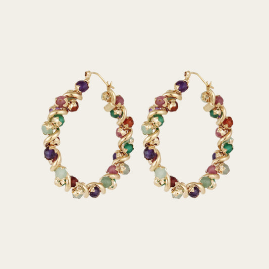 A pair of gold-plated hoop earrings adorned with multiple colorful semi-precious stones.