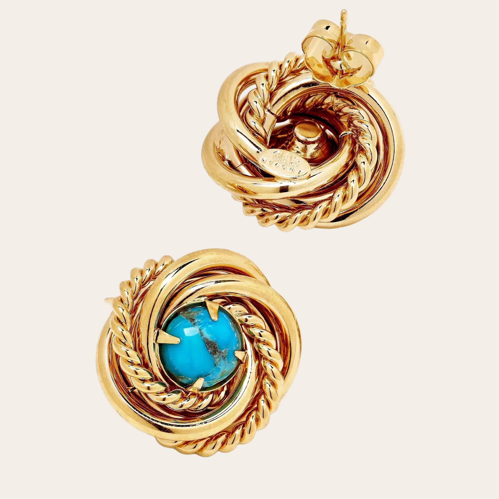 Gold earrings with turquoise stone on a white background