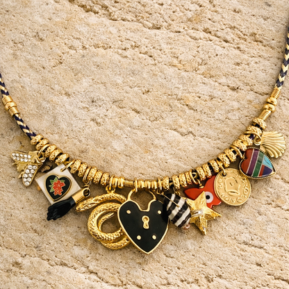 Necklace with various charms on a textured beige surface