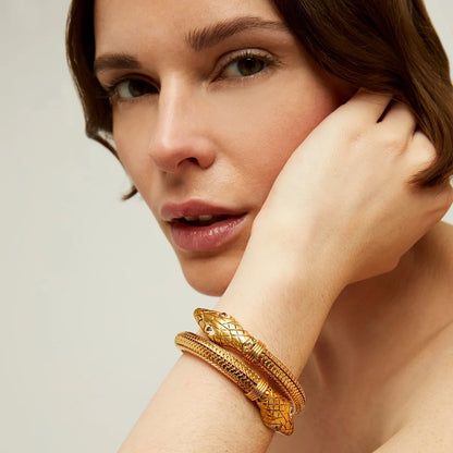 Woman wearing a gold bracelet on a neutral background