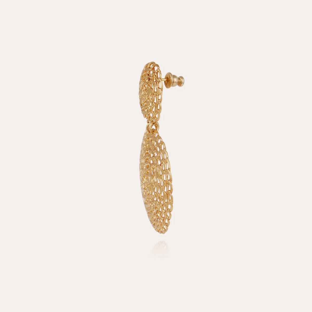 A single gold dangle earring with a textured, openwork mesh design, shown against a plain light beige background.
