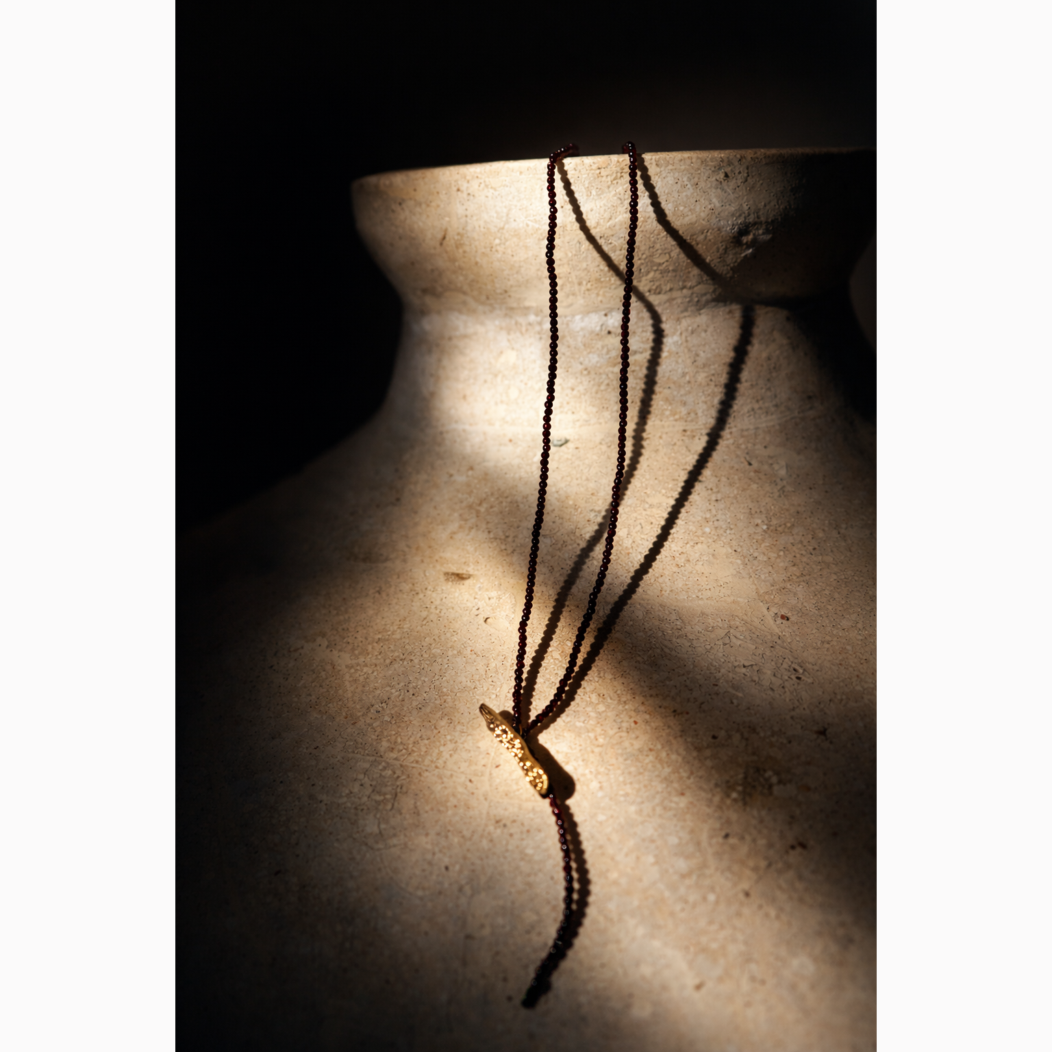 Necklace with a pendant on a textured surface