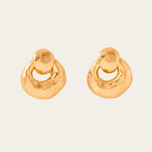 Pair of gold hoop earrings on a beige background