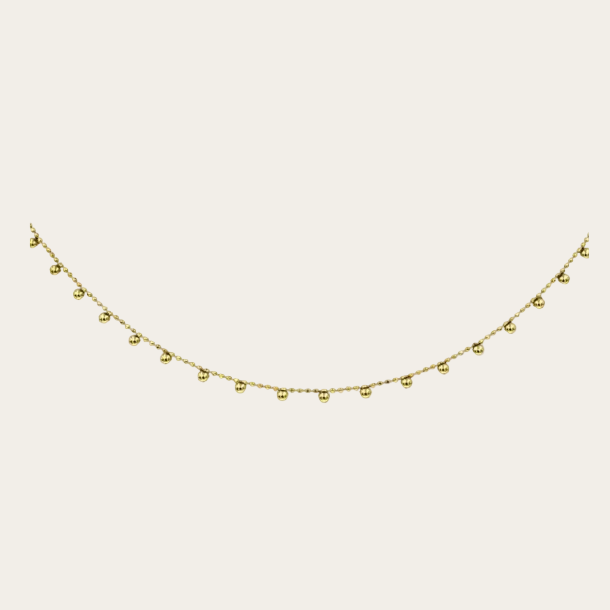 Gold necklace with small beads on a white background