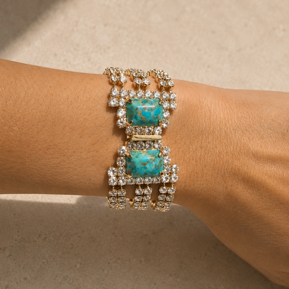Elegant bracelet with turquoise stones and gold accents on a wrist against a neutral background