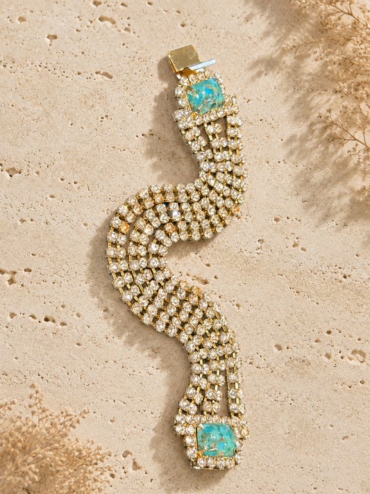 Decorative bracelet with turquoise stones on a textured beige surface