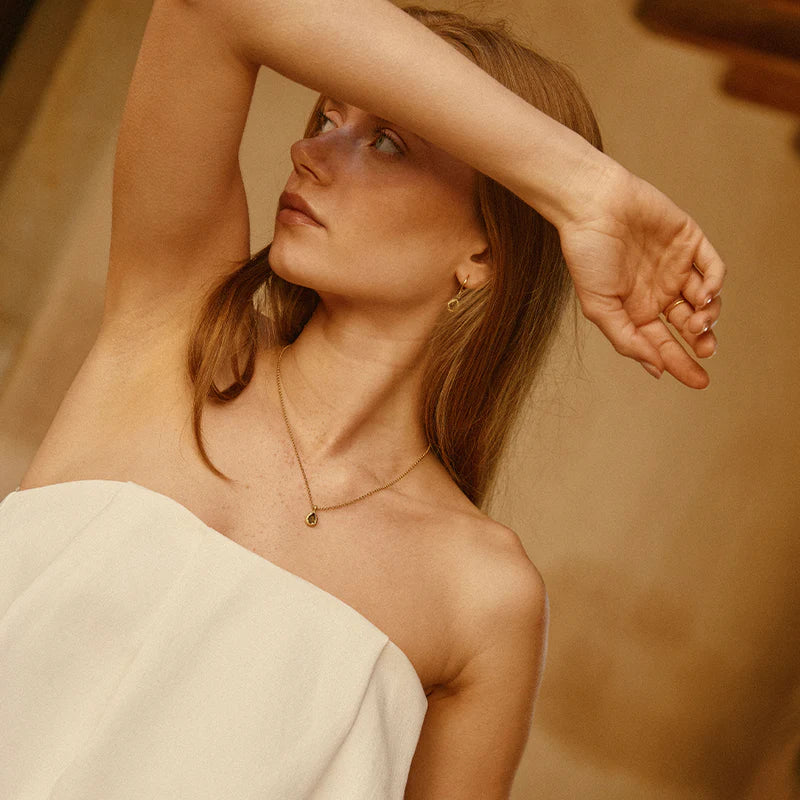 Woman with a strapless dress against a warm-toned background