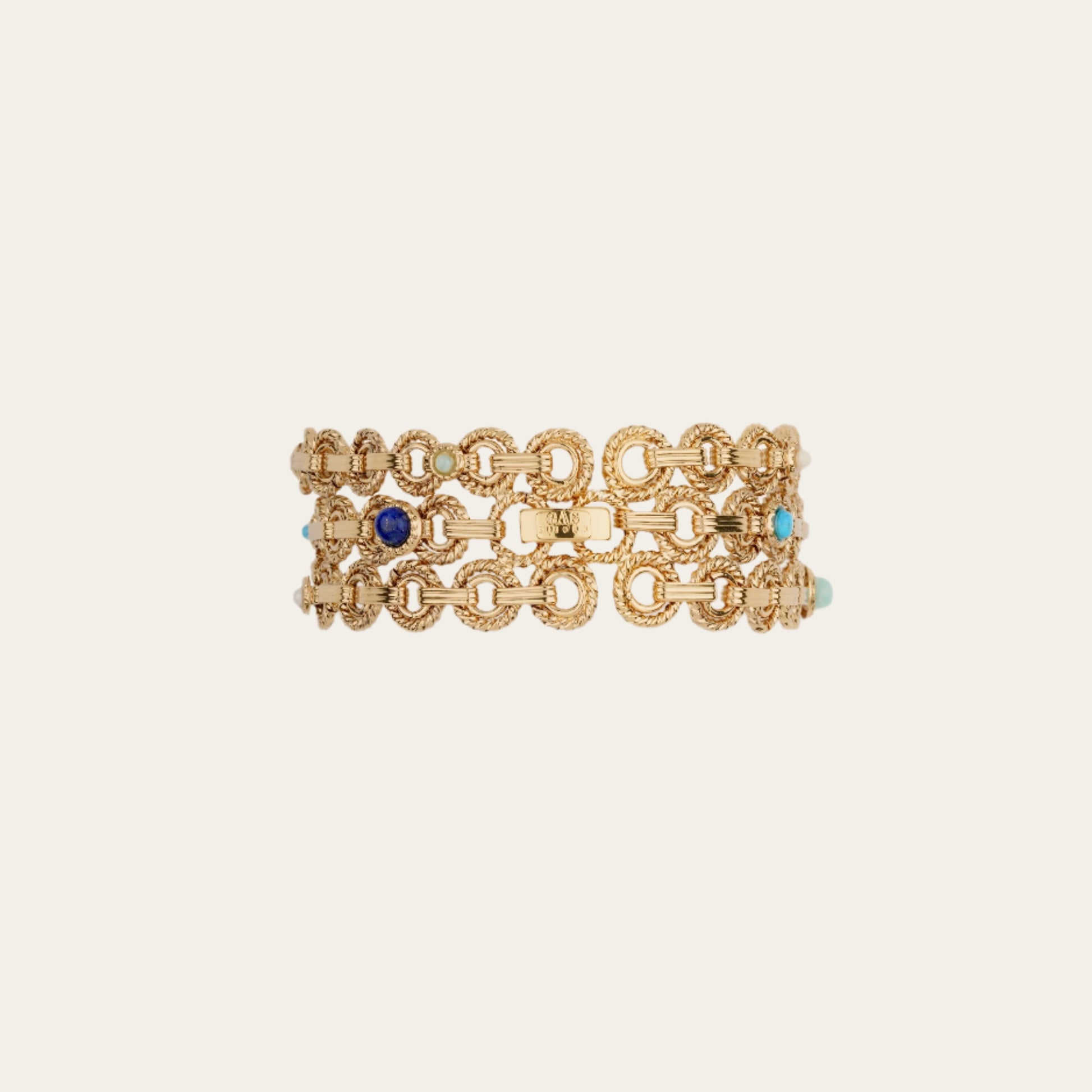 Gold chain bracelet with blue and turquoise stones on a beige background