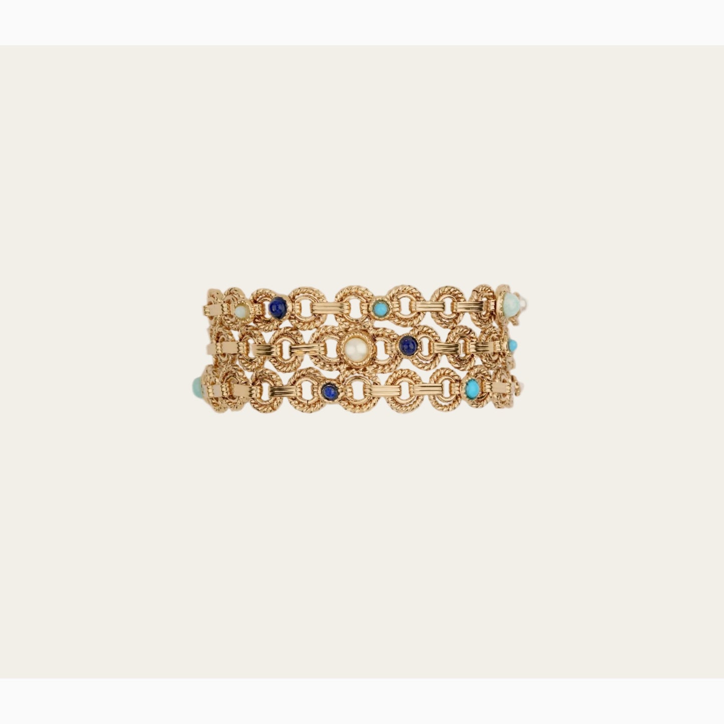 Gold bracelet with blue and turquoise stones on a beige background