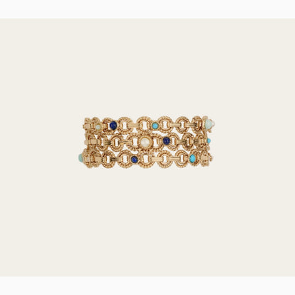 Gold bracelet with blue and turquoise stones on a beige background