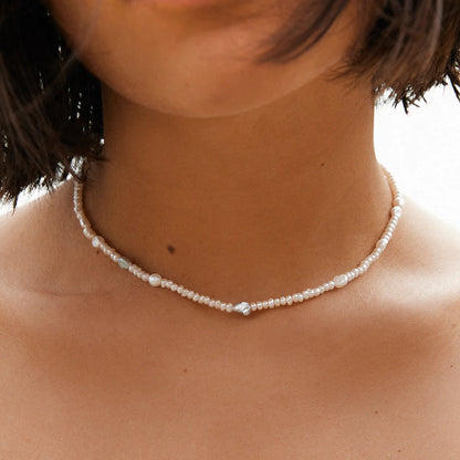 Pearl necklace worn by a person with blurred background