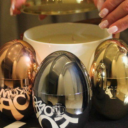 3 metallic egg shaped candles with large ceramic candle in the back