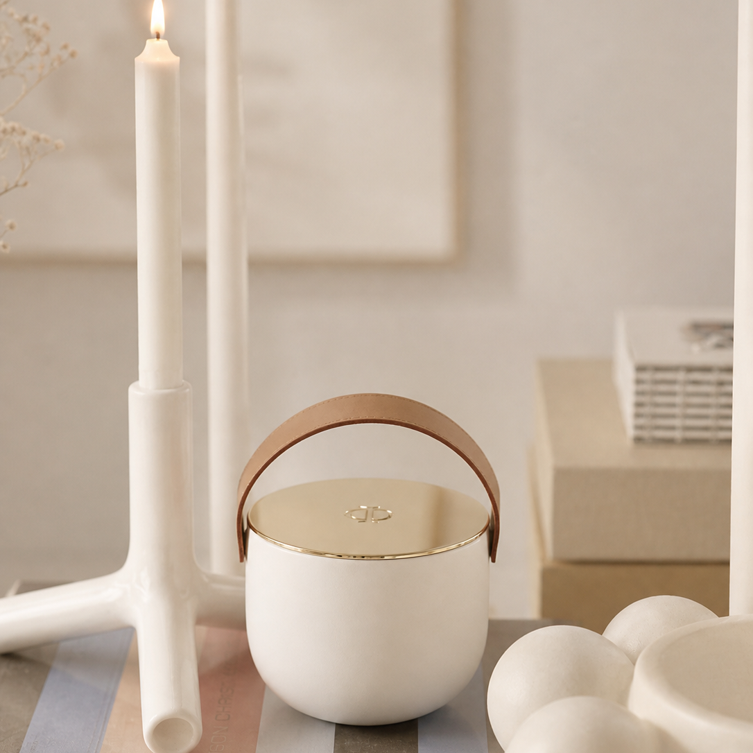 white ceramic candle with gold lid on coffee table with books