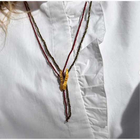 Necklace with a gold clasp on a white shirt