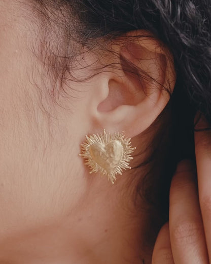 video of close up of womans ear and godld heart earring