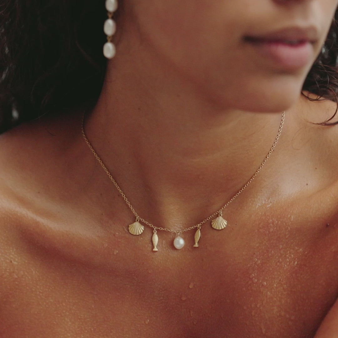 video of necklace with charms on a womans neck