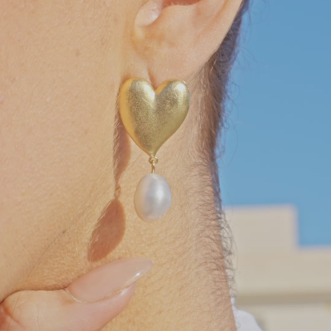 pearl and gold heart earrings on woman