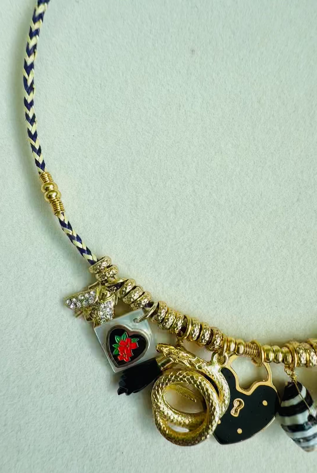 Necklace with charms and threaded cotton on neutral background
