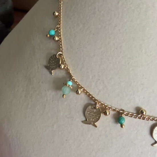 gold necklace with hanging fish and coloured stones