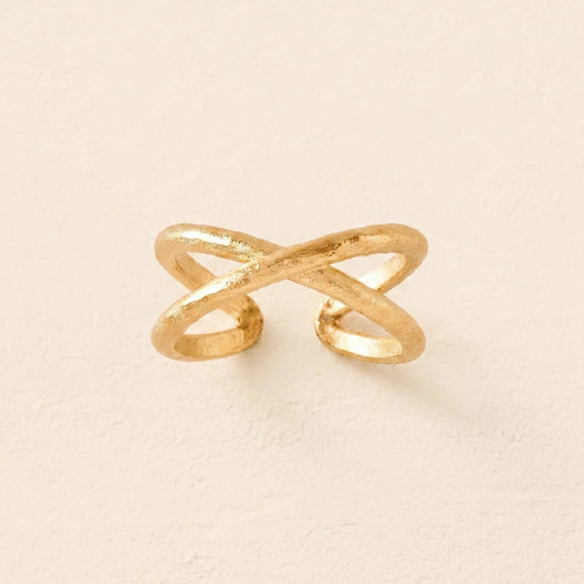 Gold ring with a unique design on a beige background